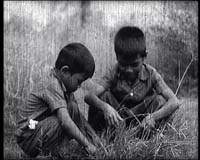 Phal et son frère jouant dans l'herbe qui envahit S21. Image extraite du film "Les enfants du Cambodge" (Direction du cinéma du Cambodge)